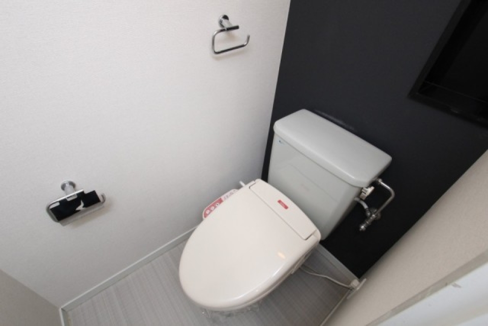 シャワー付きトイレ。右上はトイレットペーパーなどを入れられる収納棚。