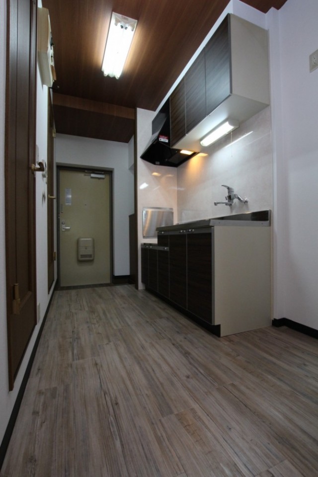 お部屋からキッチン、玄関を見る。左はトイレへ続く扉。