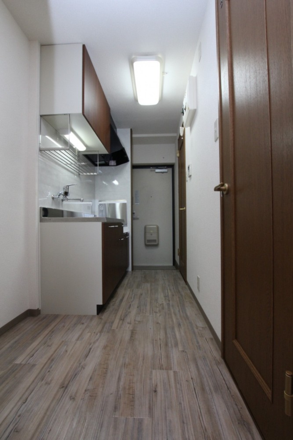 お部屋からキッチン、玄関を見る。右はトイレへ続く扉。