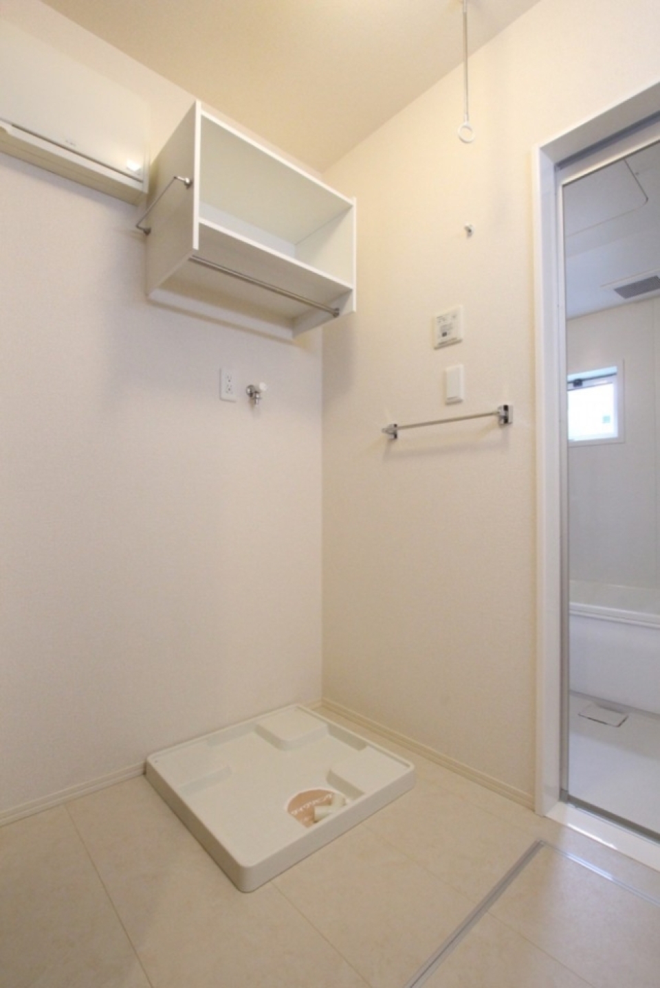 室内物干しと棚付きの洗濯機置き場。