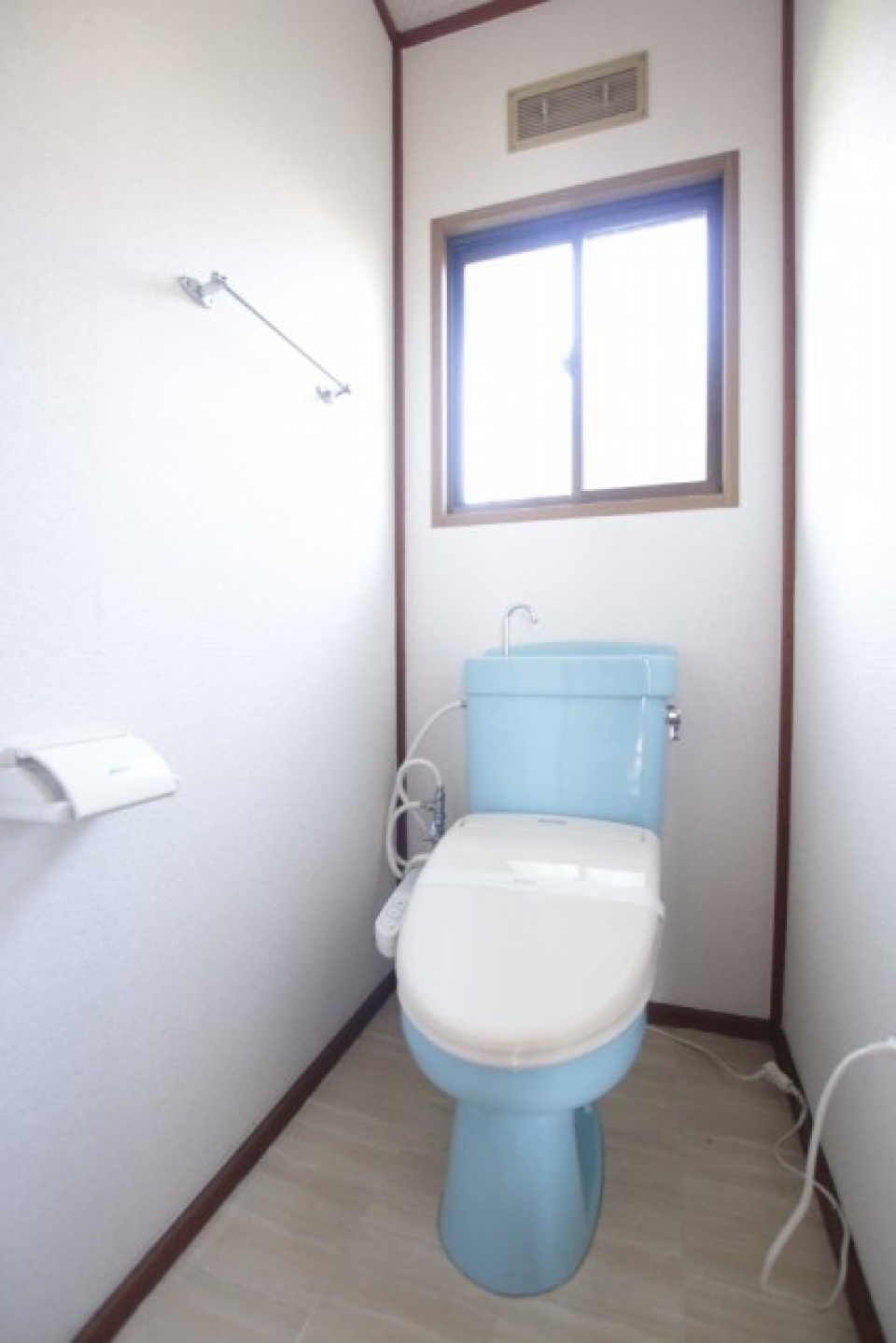 水色が差し色のトイレ。窓付きです。