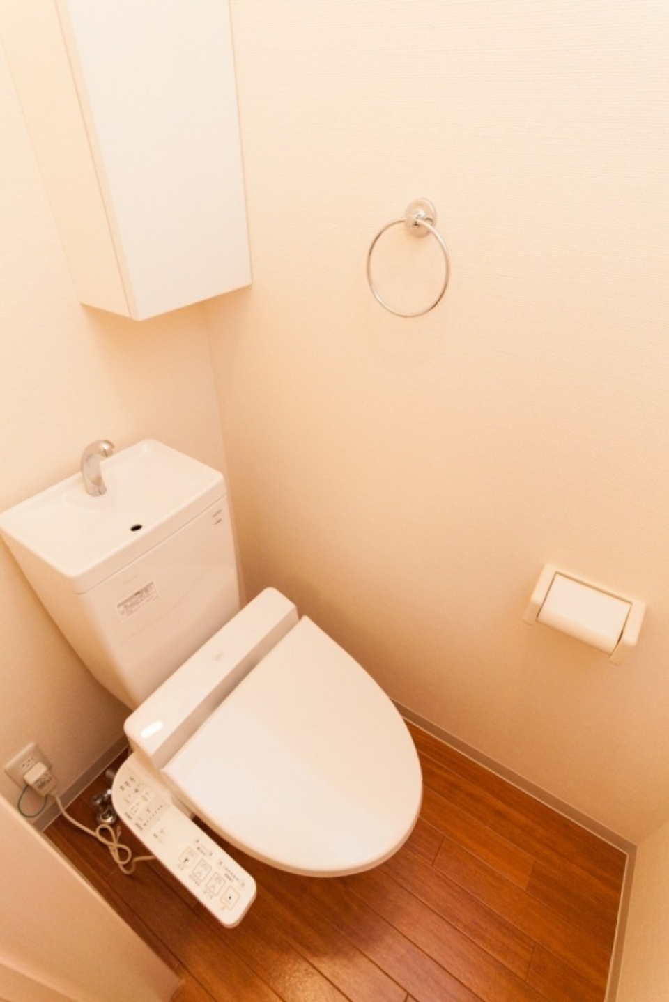 シャワー付きトイレ。右上はトイレットペーパーなどを入れられる収納棚。