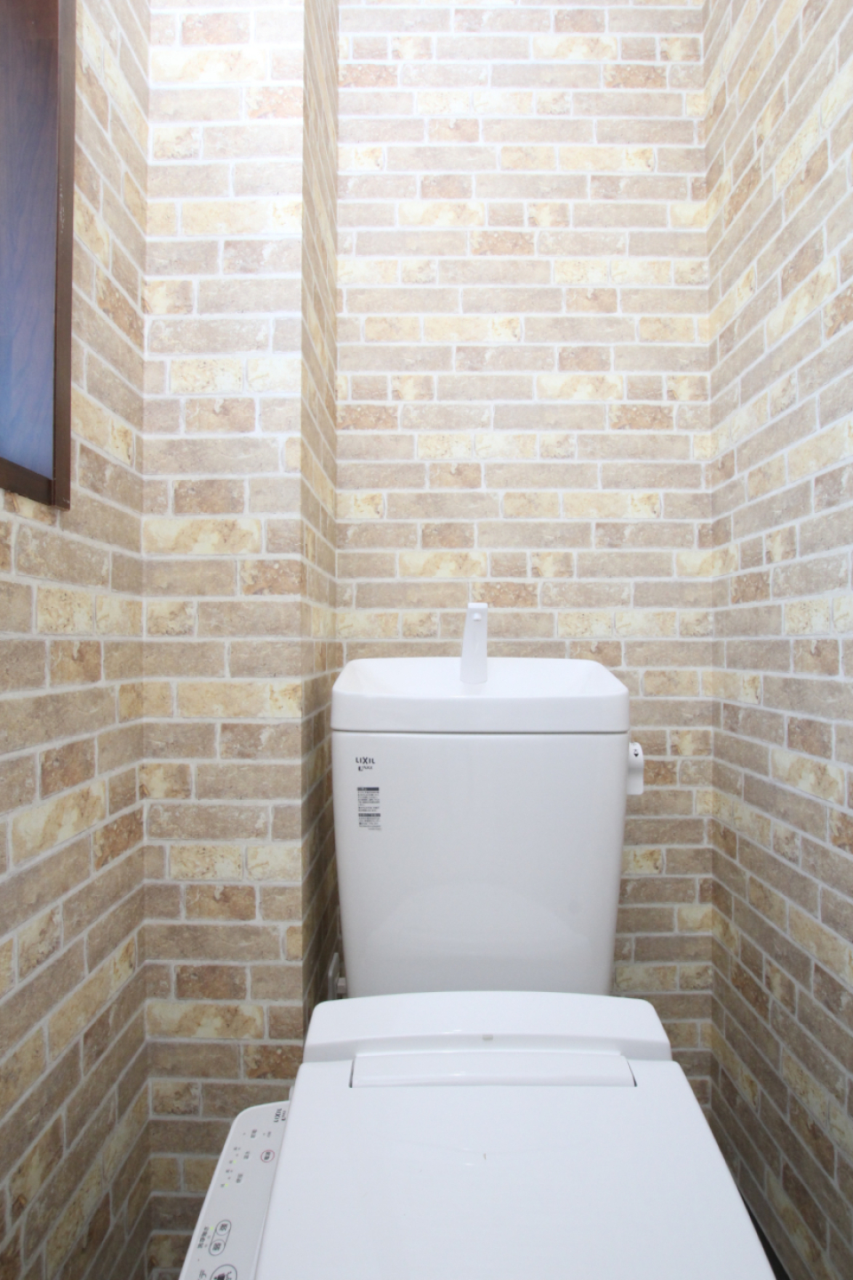 トイレも脱衣洗面所と同じ煉瓦のクロス