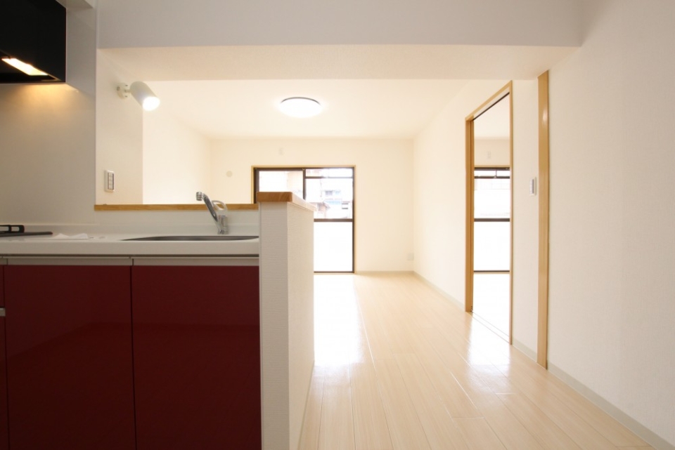 白いナチュラルな空間に映えるレッドのシステムキッチン。