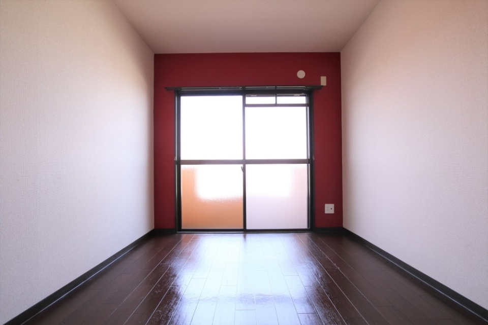 6帖の洋室。赤い壁の窓際が印象的です。