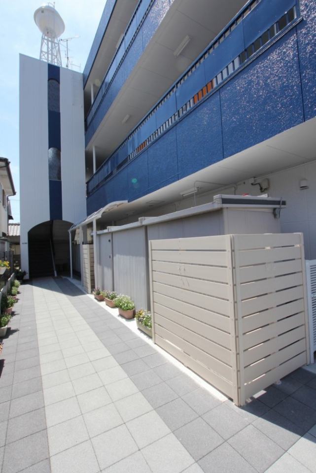 マンション外観。青&times;白の配色が爽やかで、エントランス部分も整備されています