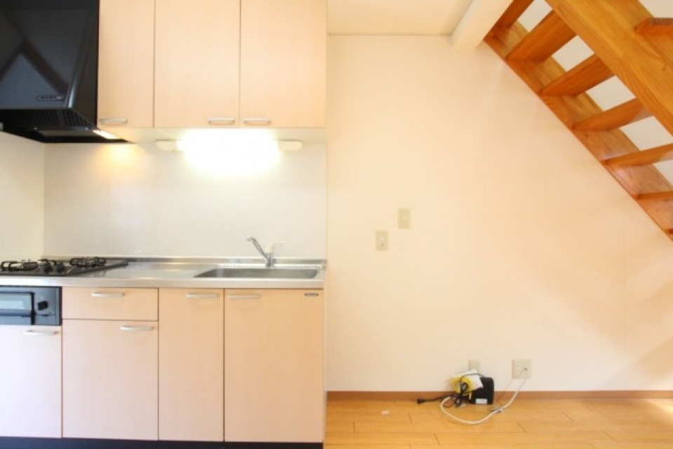 シンプルなキッチン。階段下は収納スペースにも