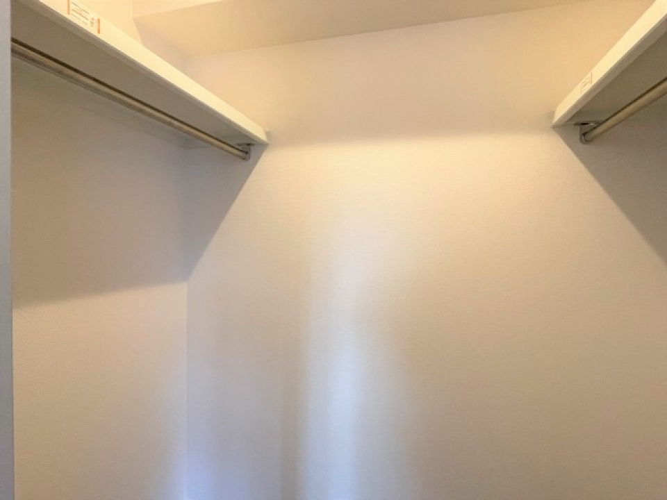 両サイドにハンガーパイプのついたウォークインクローゼット