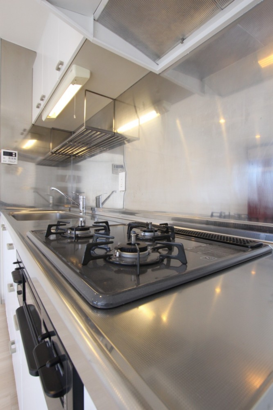 キッチンは３口コンロとグリルの付いたシステムキッチン。