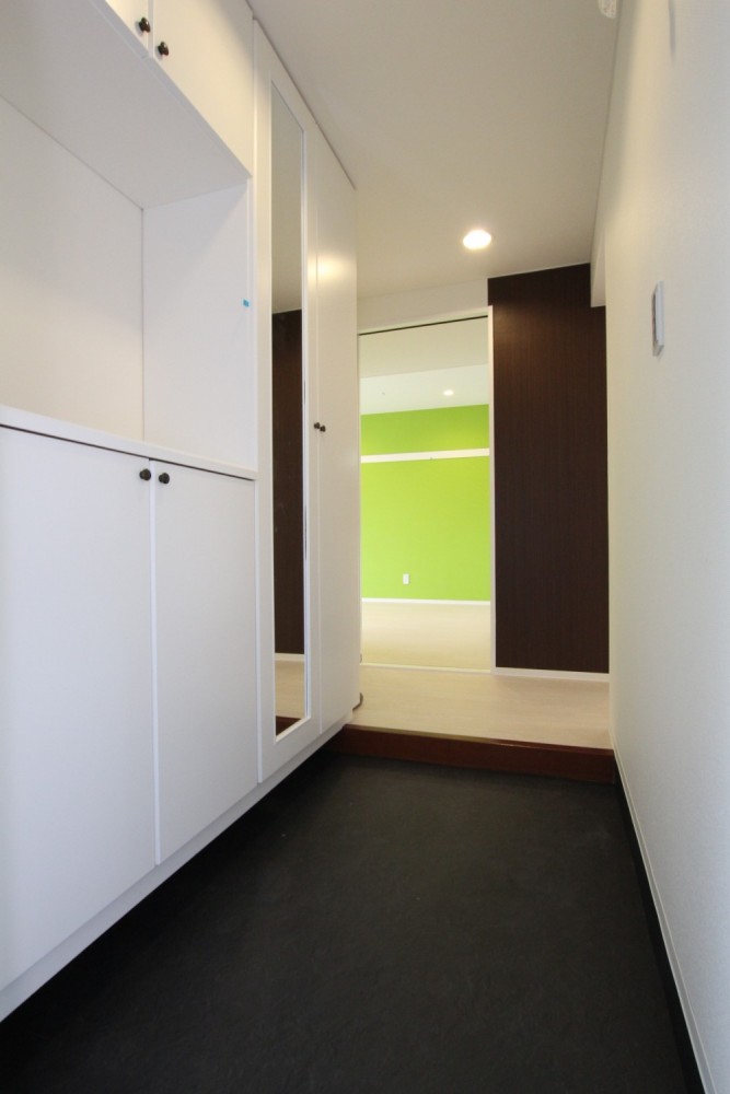 玄関開けた瞬間からグリーン壁紙が目につく。