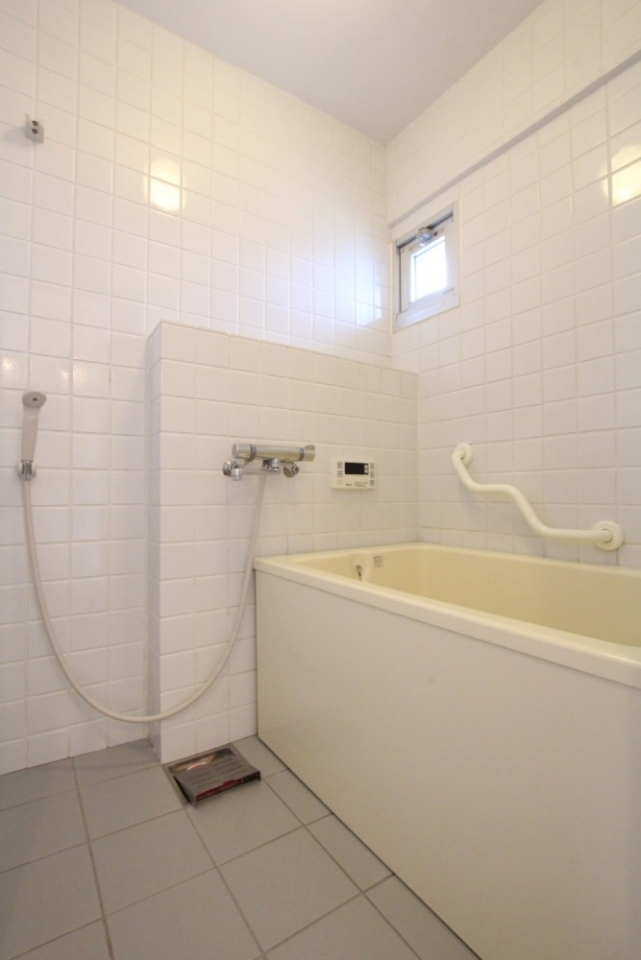 浴室はタイルの壁に囲まれています。手すり付き！