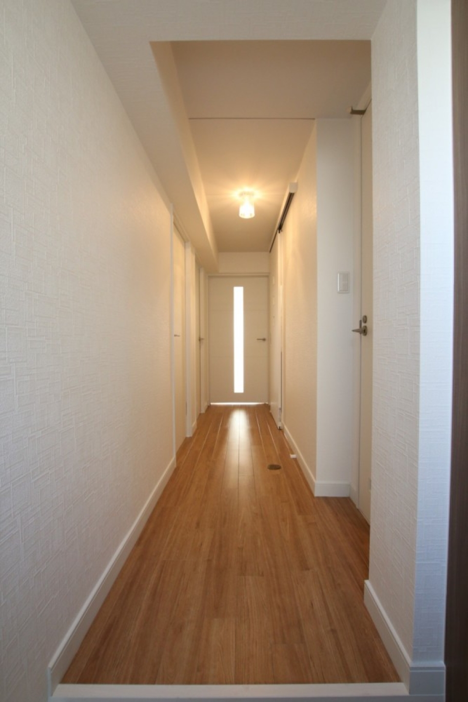 廊下の左右に洋室とトイレ、洗面のドアが配置されている。