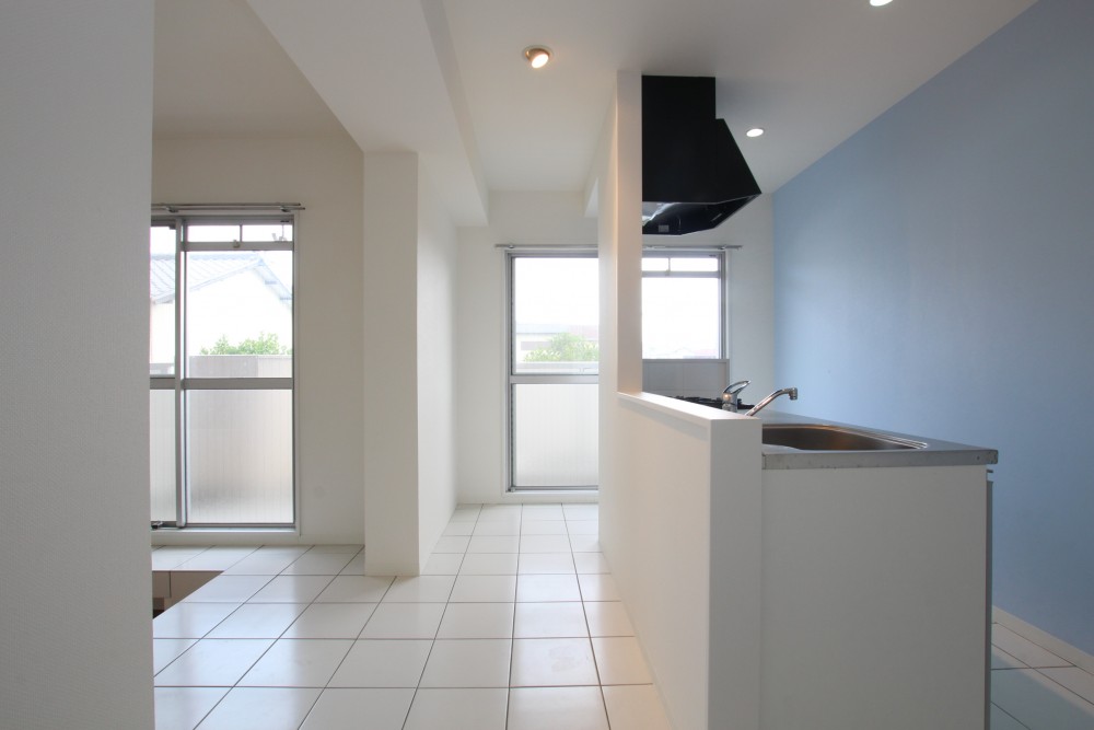 アイランドキッチンは、ツヤ感ある白いタイルの上です。