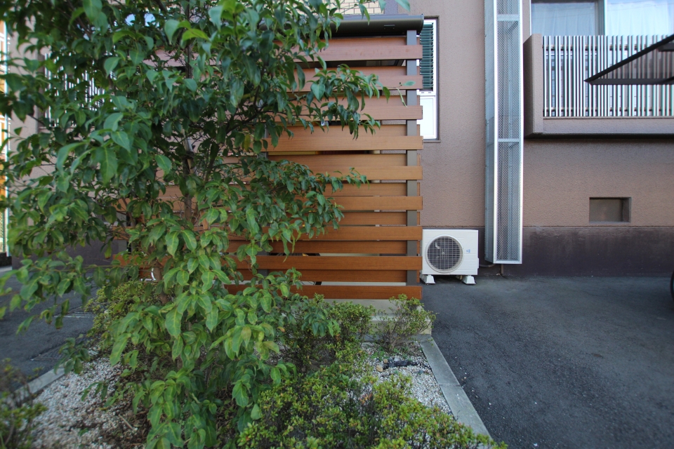 ウッドパーテーションやグリーンがオシャレなマンション外観