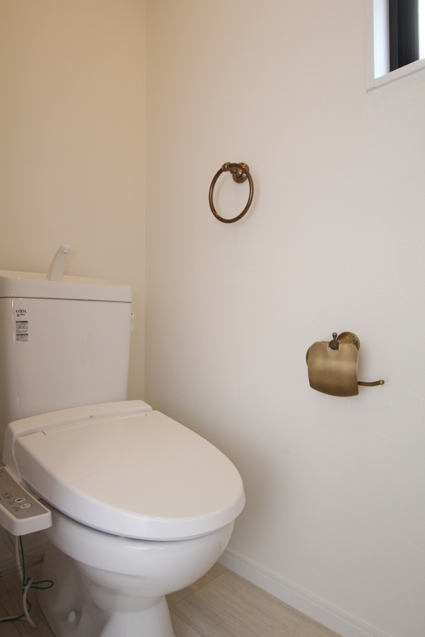 トイレ。真鍮のペーパーホルダーやタオル掛けがアクセサリーのよう