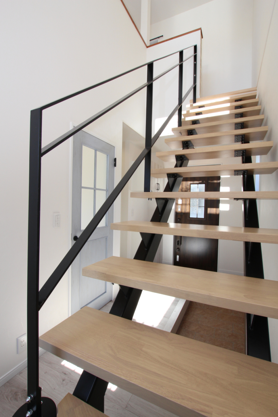 スケルトン階段のアイアンが空間を引き締めている