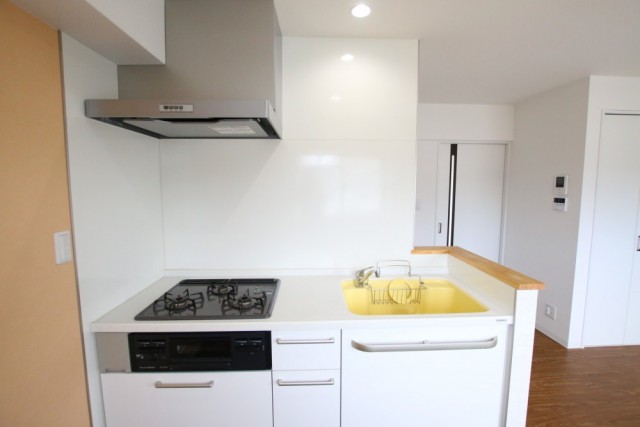 キッチン。黄色のシンクがかわいい。3口コンロ