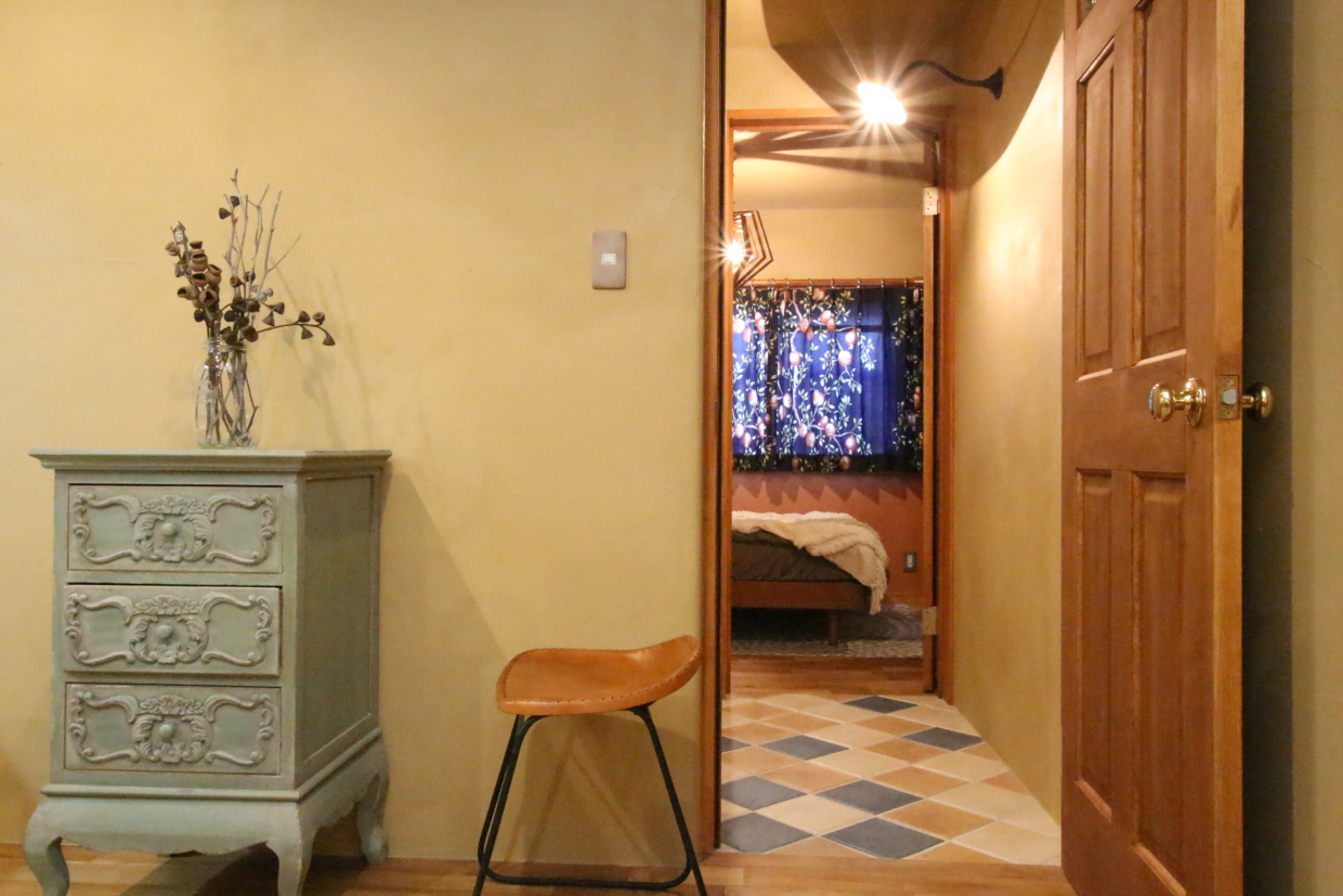 奥に見えるカーテン、タイルのフローリングの内装がオシャレ。