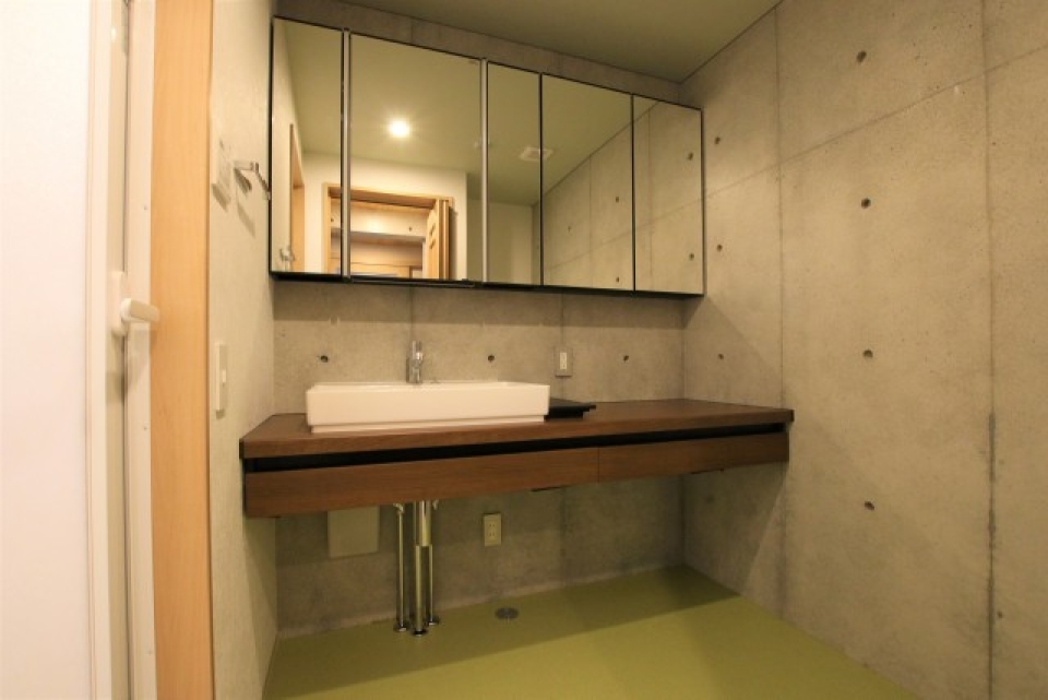 シンプルで美しい洗面台。脱衣スペースはライトグリーン。