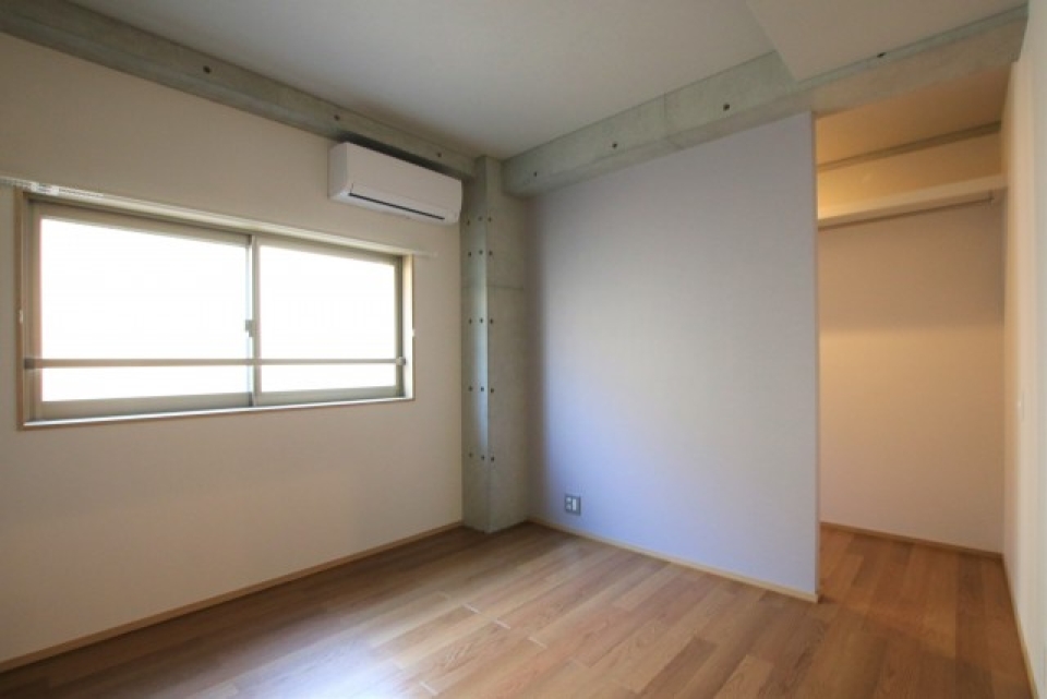 玄関近くの5.4帖の洋室。奥には扉のない収納スペースが見えます。