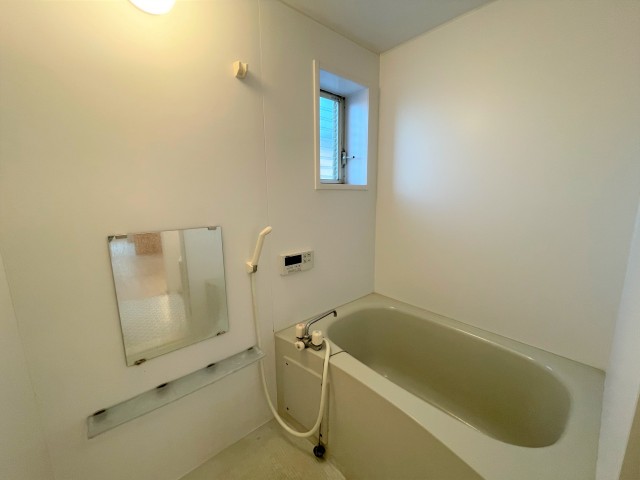 窓と鏡がついた浴室。