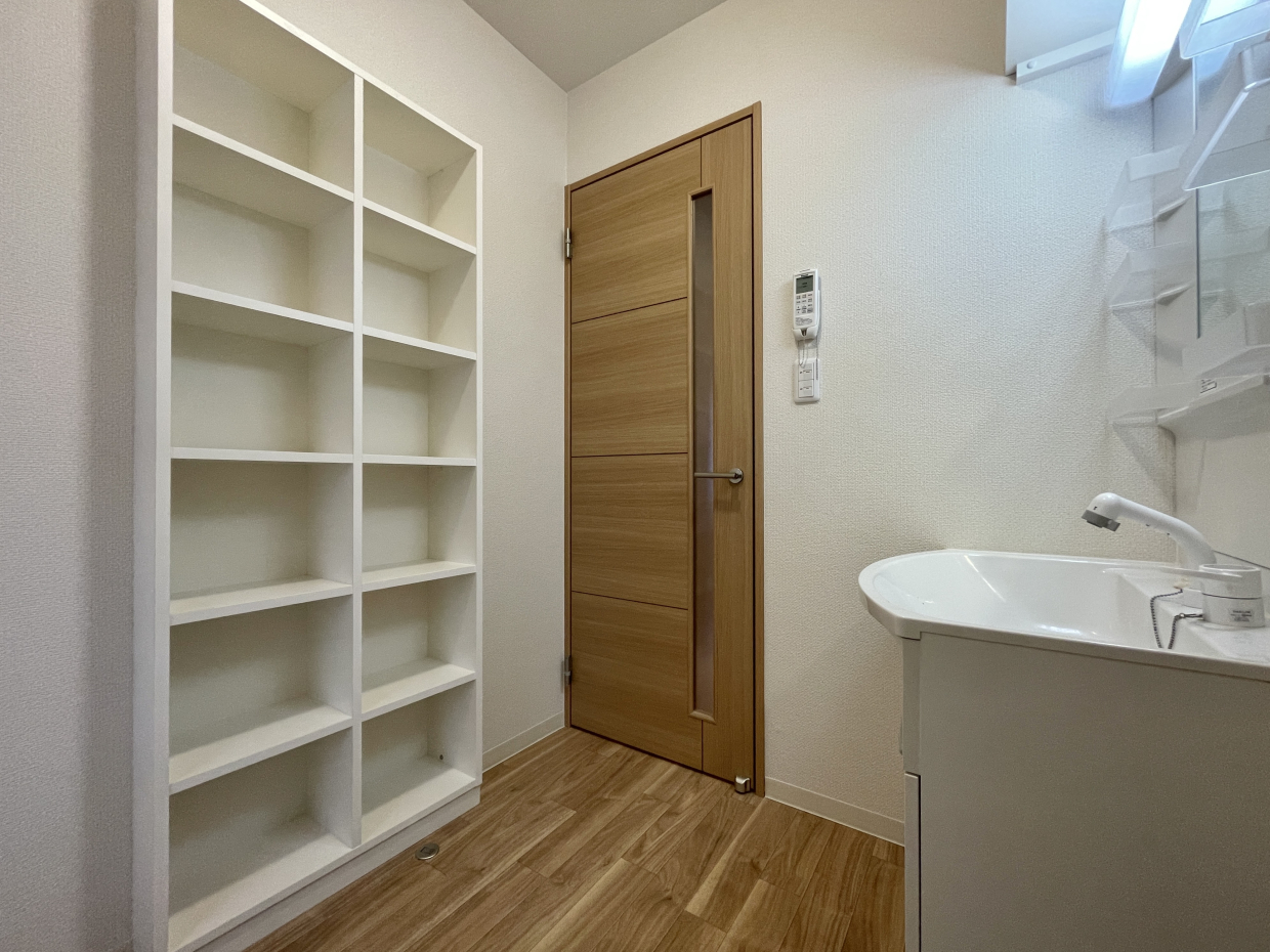 脱衣洗面所。ここにも備え付けの棚が。タオルもすぐ置ける