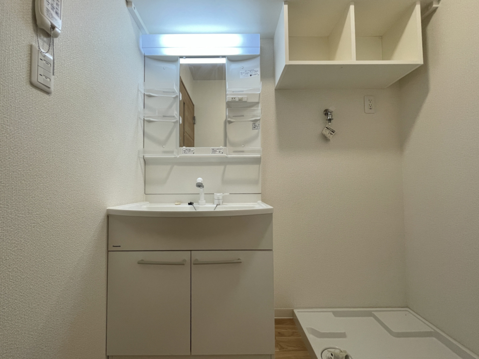 洗面台。お隣には洗濯機置き場。洗濯機置き場上には洗剤を置ける棚もあります
