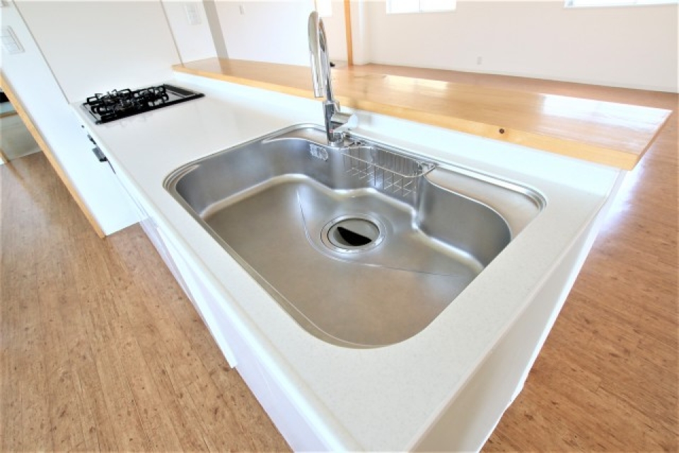 3口コンロ、シンク広々、作業スペースもしっかり確保されたシステムキッチン。