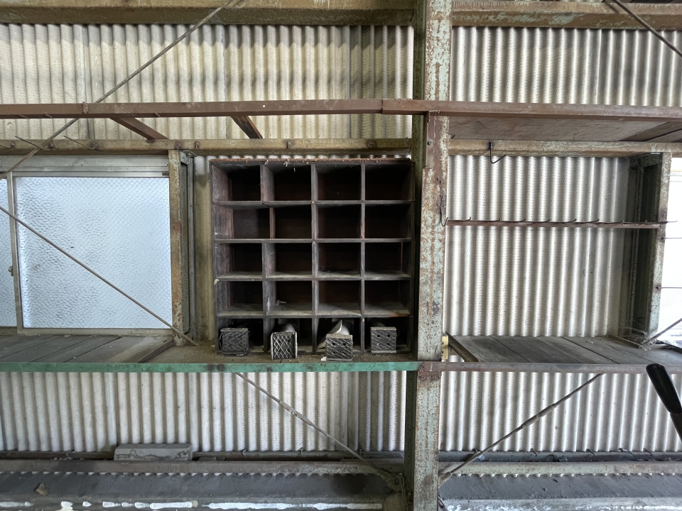 壁側には修理工場らしい棚が設置されている。