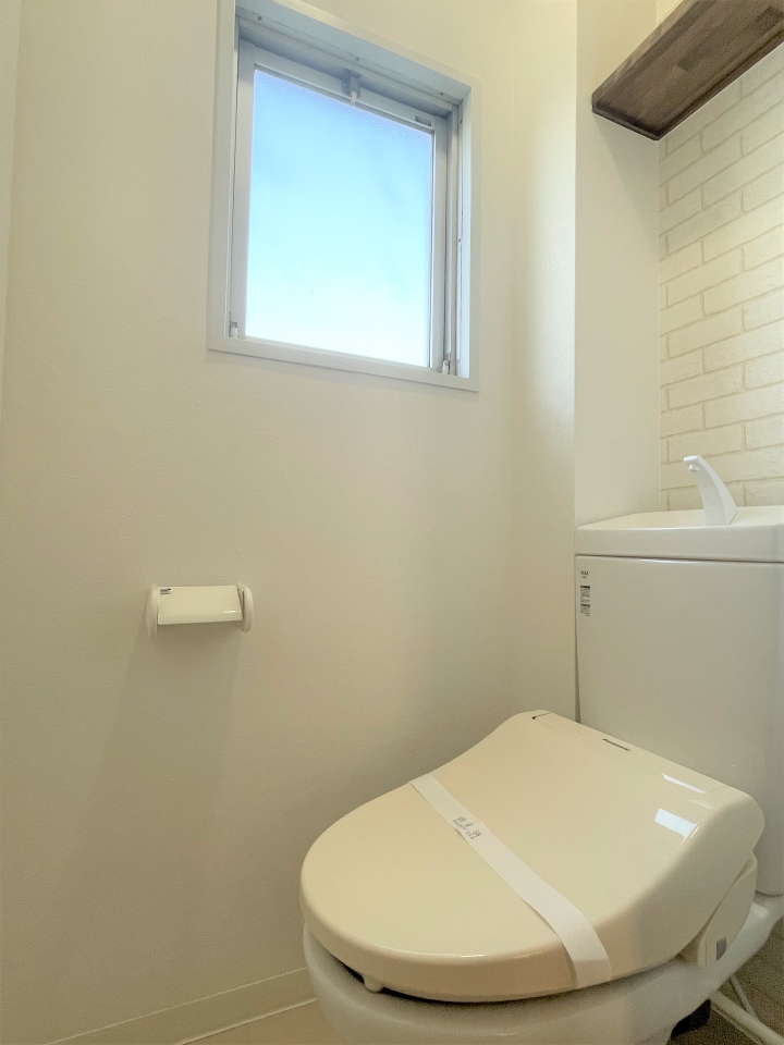 真と、棚付きの明るいトイレ。