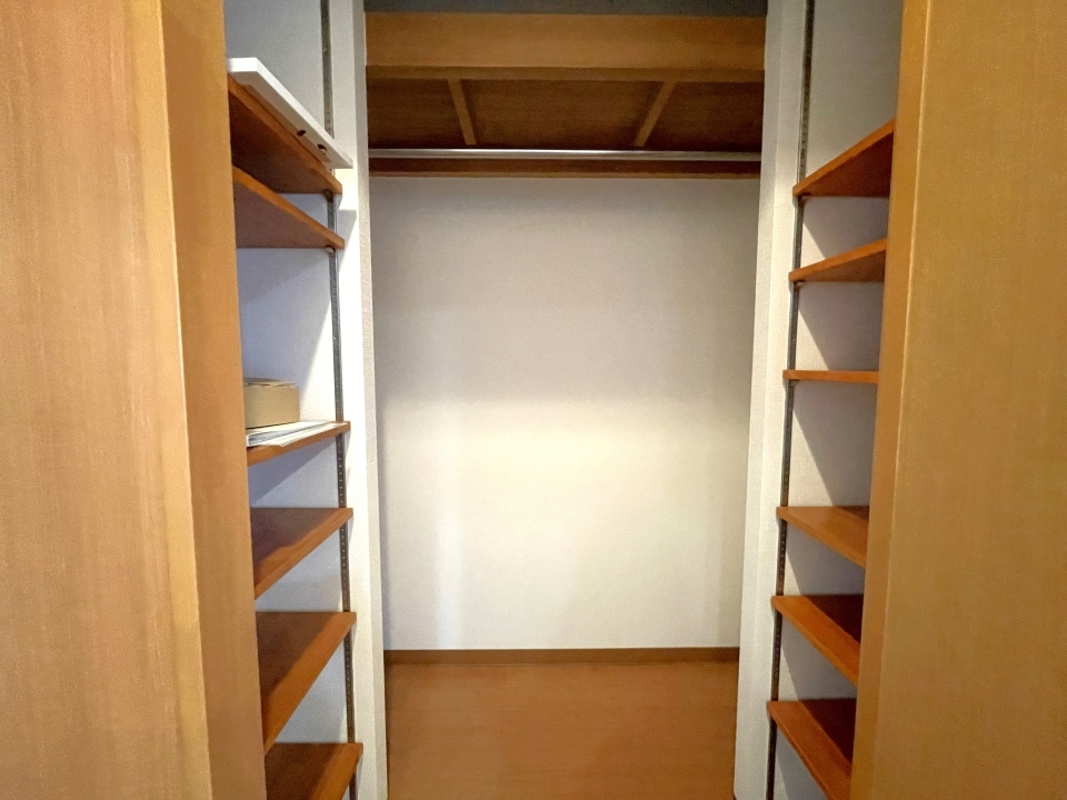 実はこの中央カウンターには可動棚＋ハンガーパイプ付きの大容量収納が隠されています。