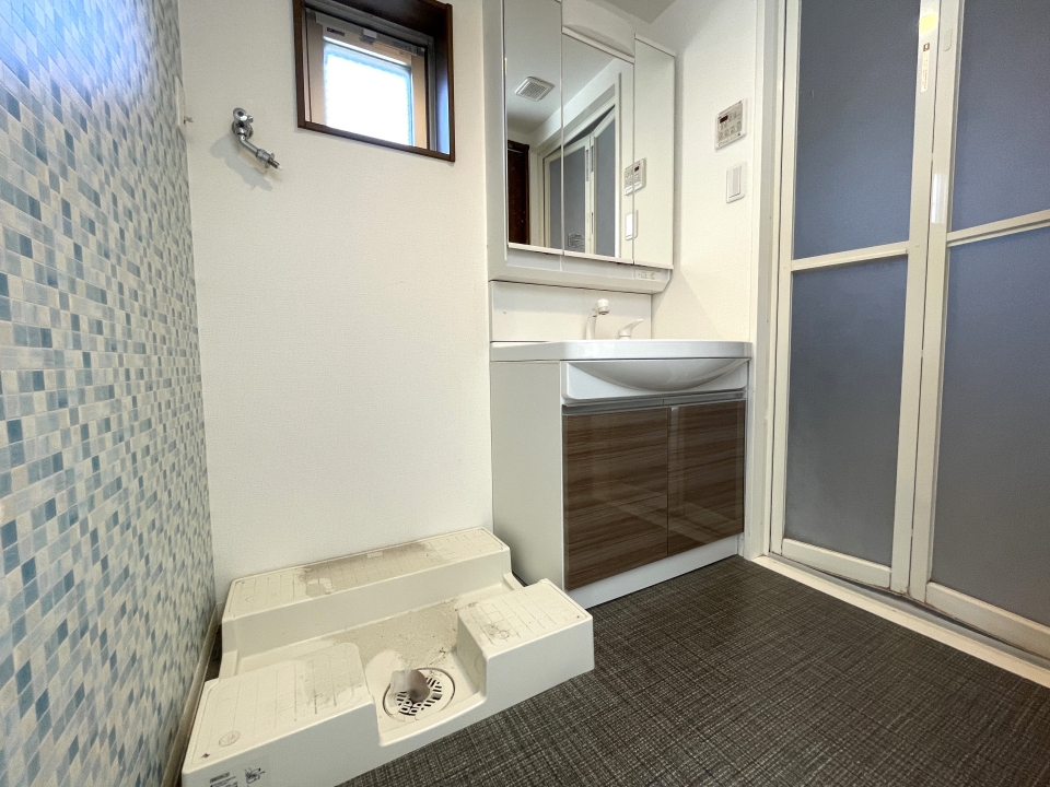 洗面脱衣所の壁は水色タイル模様。