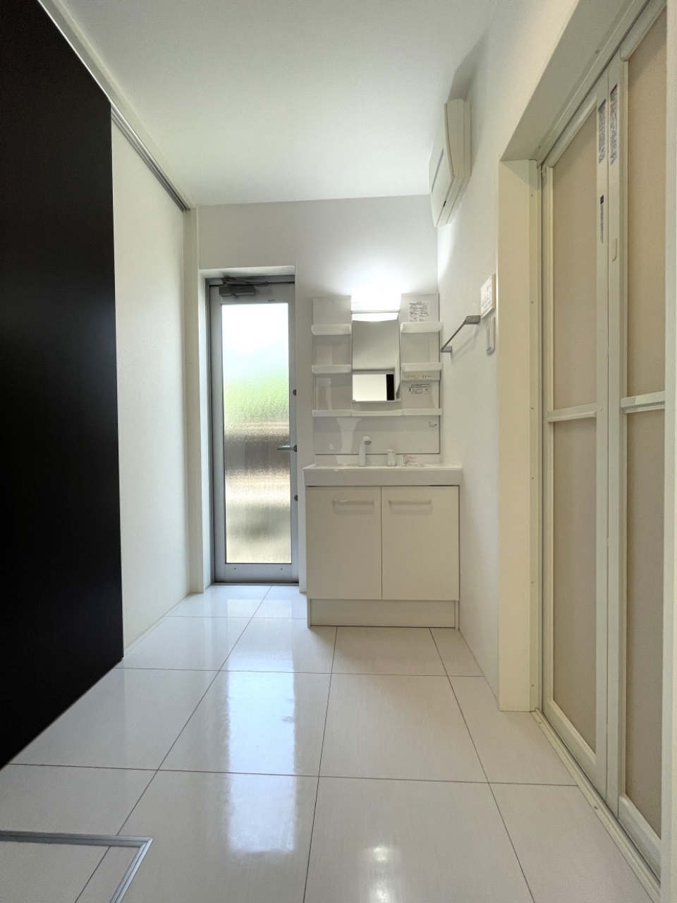 洗面所スペース。洗面台のお隣の扉は裏口です