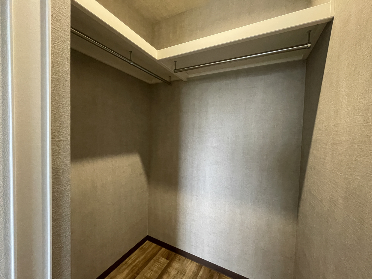 クローゼットはＬ字型にパイプハンガーが付いていてたっぷり収納できそう。