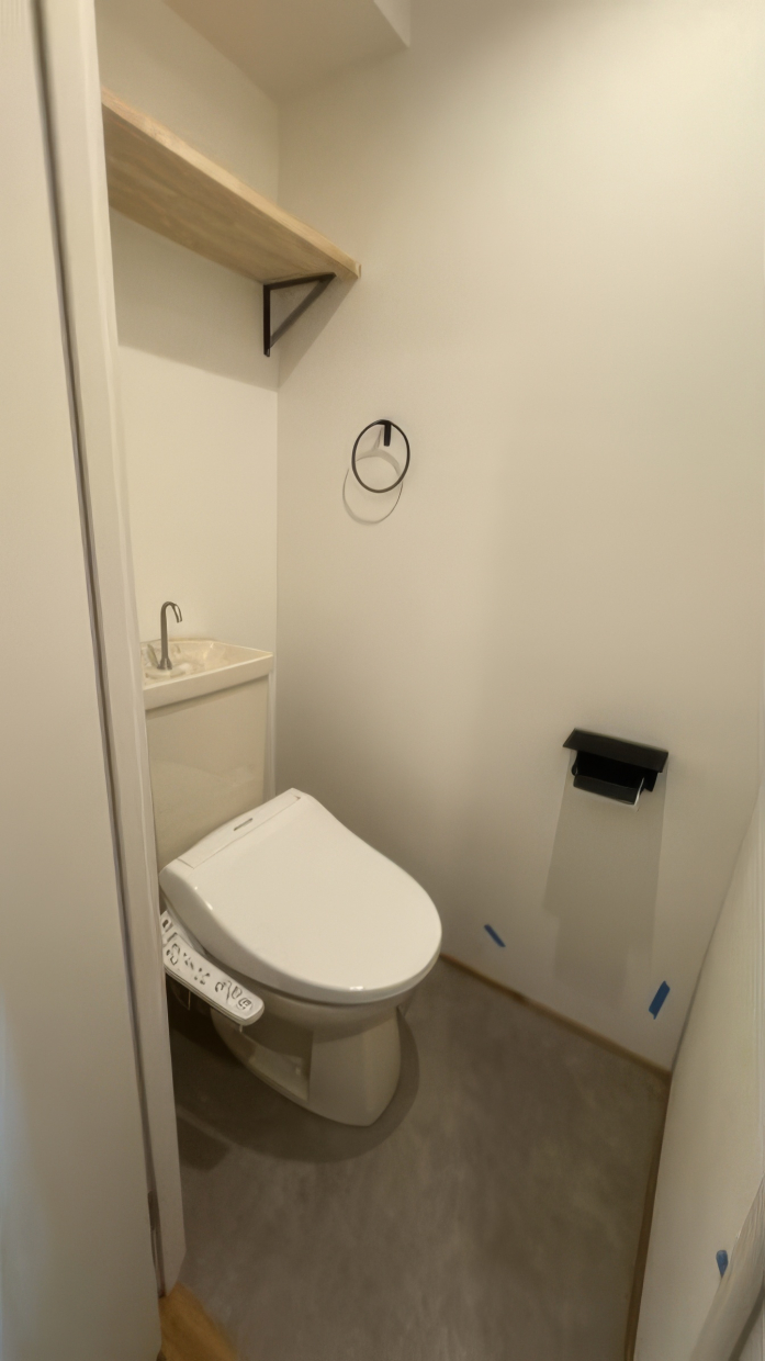 トイレにも簡易棚付き、ペーパーホルダーとタオル掛けが黒なのがアクセント