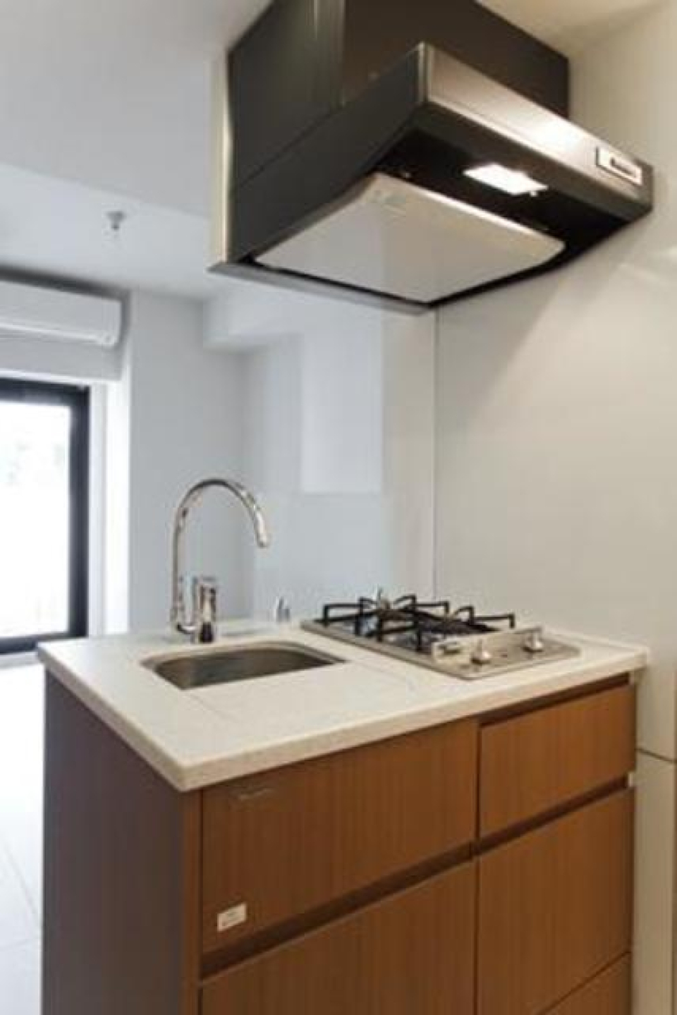 ブラウンのコンパクトなキッチン※写真は同タイプ住戸です。