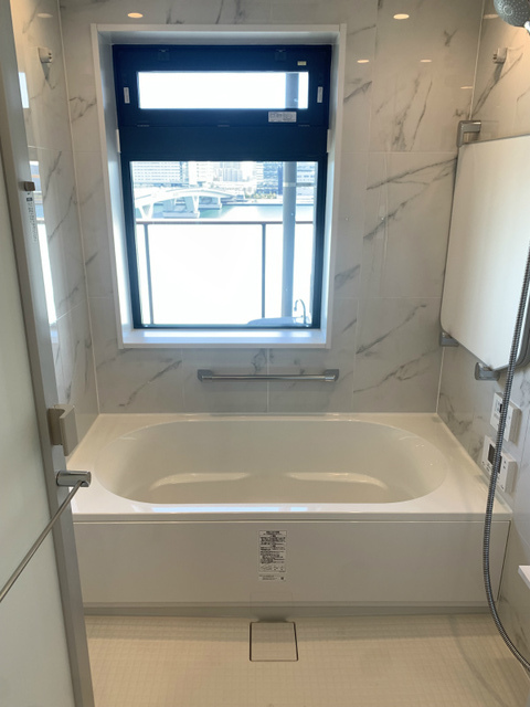 大理石調のパネルがある浴室。