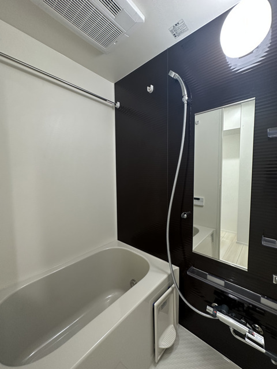 ダークトーンのパネルが採用された浴室、