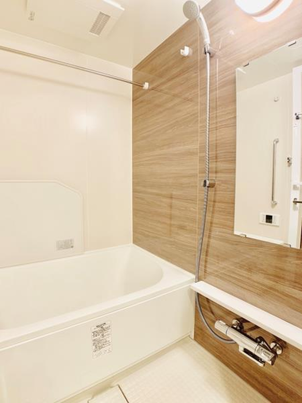 ナチュラルな木目調のパネルの浴室。