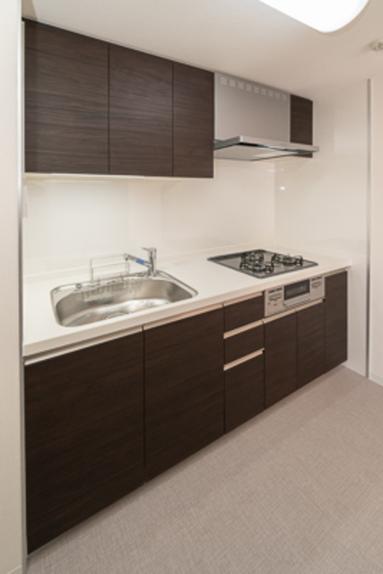 システムキッチンはブラック。※写真は同タイプ住戸です。