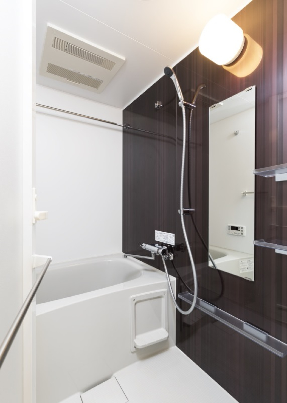 ダークトーンのパネルが落ち着いた浴室にしています。