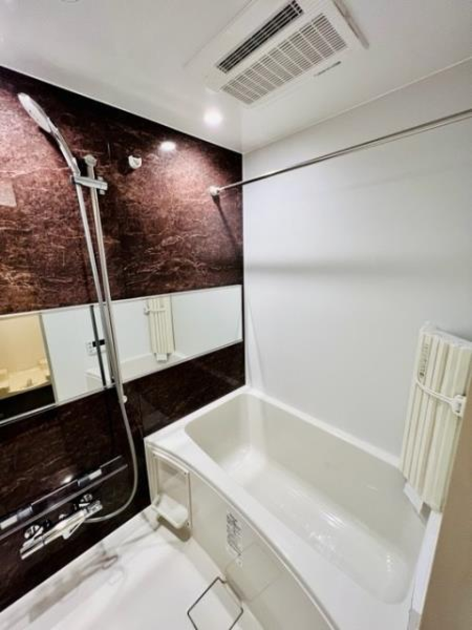 ダークトーンのパネルの落ち着いた浴室です。