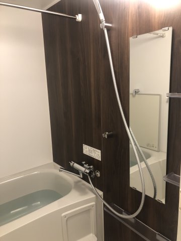 ダークトーンのパネルの落ち着いた浴室です。