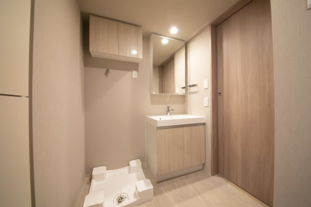 独立洗面台の隣には洗濯機を置け、頭上には収納があります。