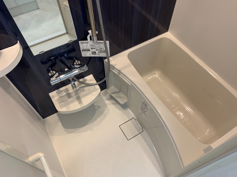 ダークのパネルに白がコントラストの浴室。