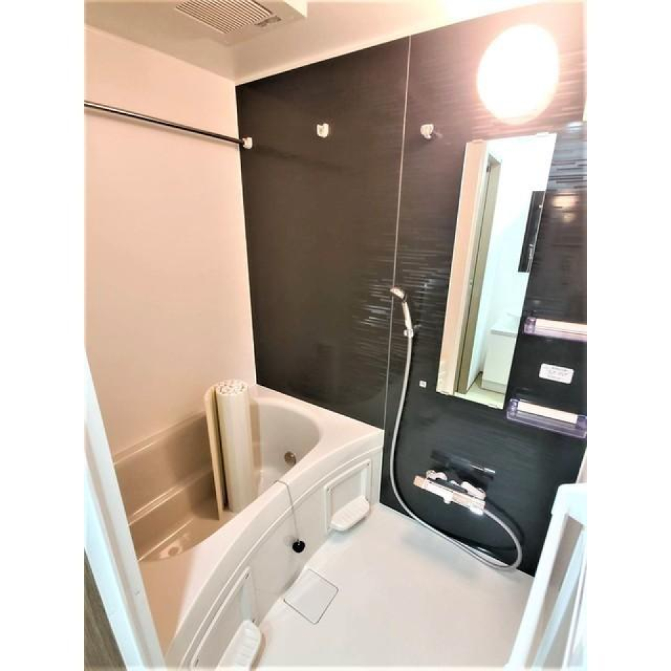 ダークトーンのパネルで落ち着いた浴室。