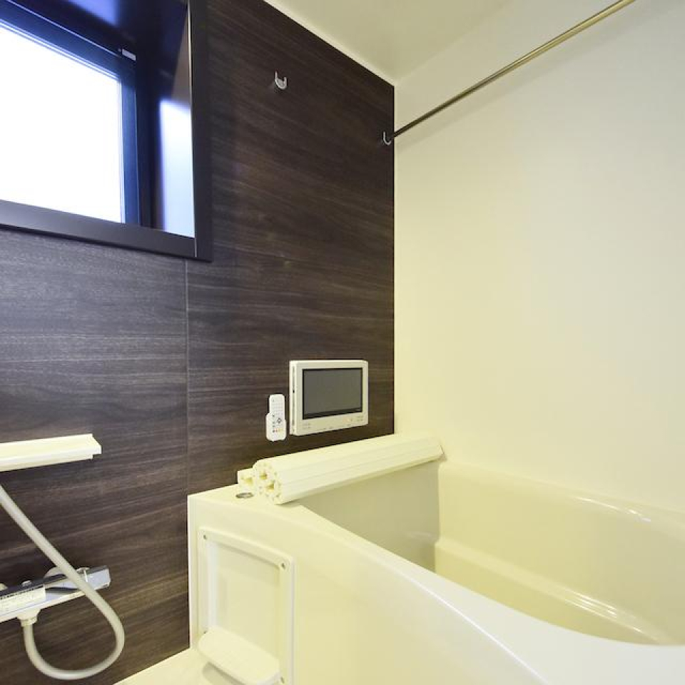 ダークトーンのパネルが落ち着いた浴室にしています。