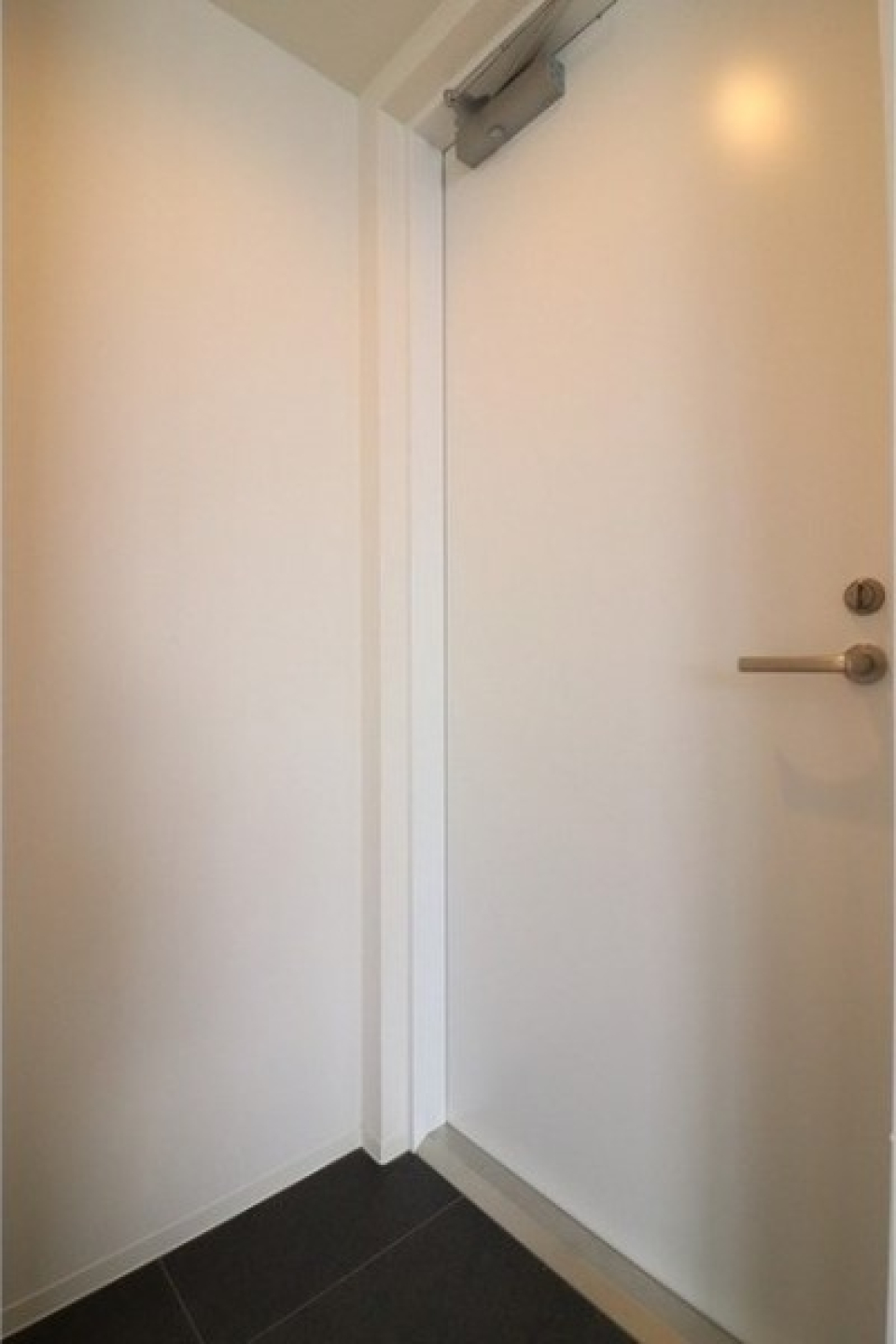 玄関の床はブラックのタイルで締まった雰囲気