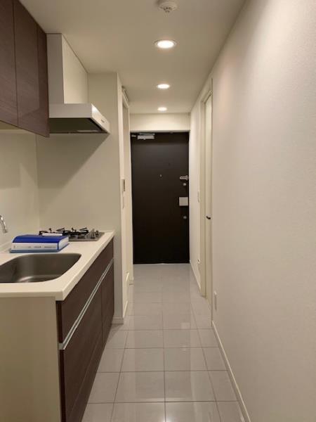 廊下にはブラウンでシンプルなキッチンがあります。