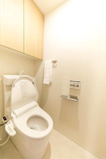 収納棚付きの清潔感のあるトイレ。